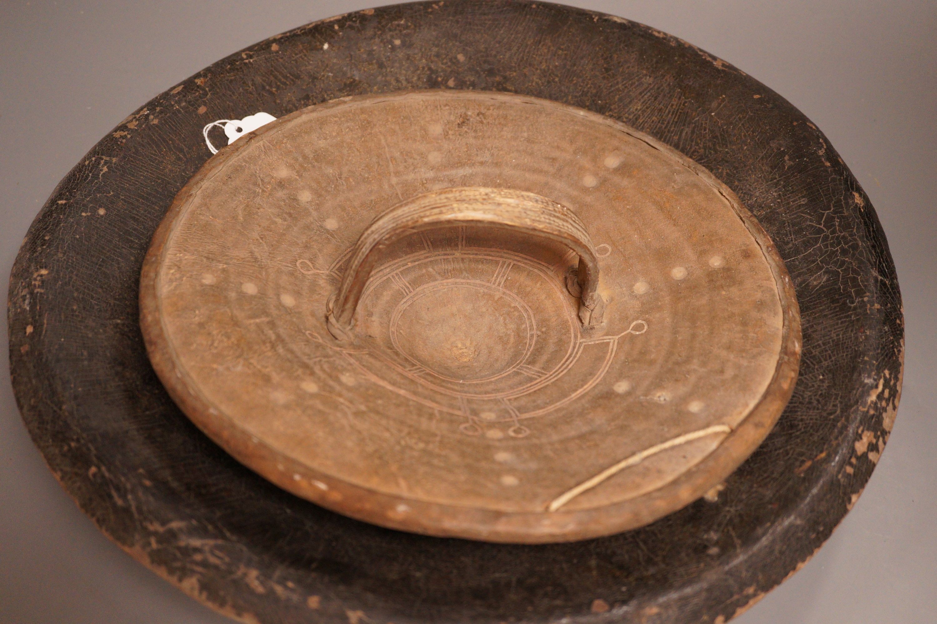 A 19th century Indo-Persian animal hide dahl shield, 41cm diameter, and an African rhino hide shield